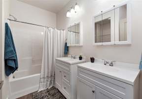 A white bathroom with a white sink and a white bathtub at Verraso Village Townhomes in Meridian, 83646