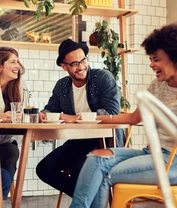 Friends Sitting at Table Laughing Together