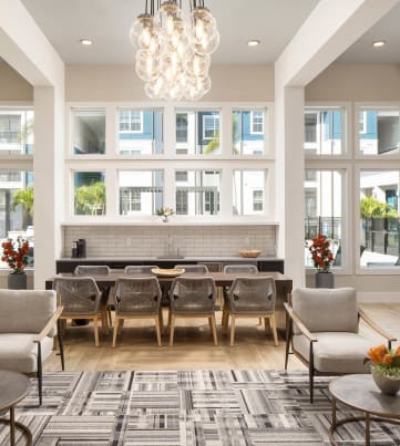a large living room with a chandelier and large windows