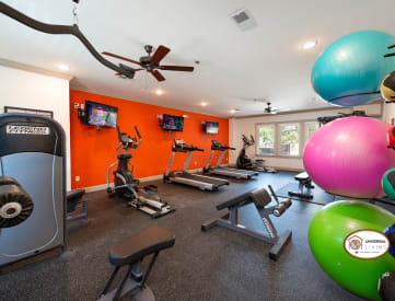 a home gym with exercise equipment and a colorful accent wall
