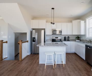 a kitchen with white cabinets and a large island with a granite countertop