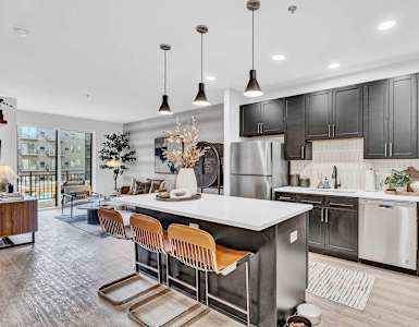 A modern kitchen with a long island and bar stools.