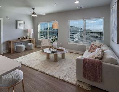 A well-lit, modern living room with a large couch and a coffee table.