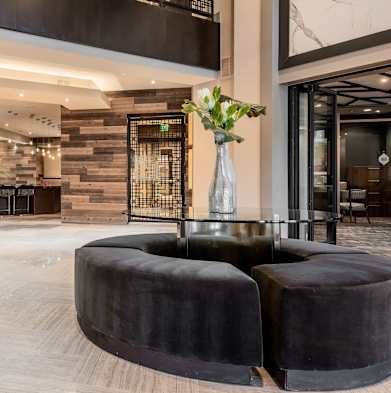 the lobby of a hotel with seating and a glass table