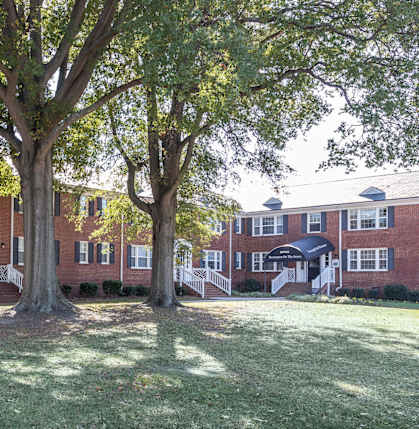 A tree in front of a red brick building.