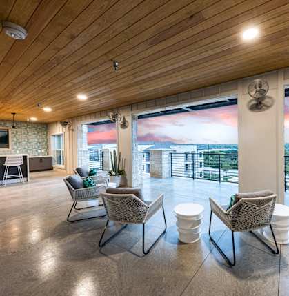 a living room with chairs and a table and a view of a balcony