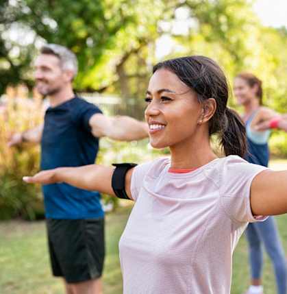 Men and Women Smiling while Doing Yoga Outside