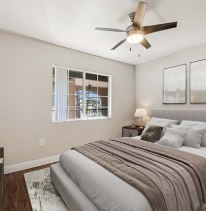 A bedroom with a bed, nightstands, and a ceiling fan.