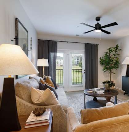 A living room with a ceiling fan and a large window.