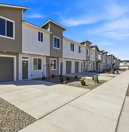 A row of houses with garages and driveways.