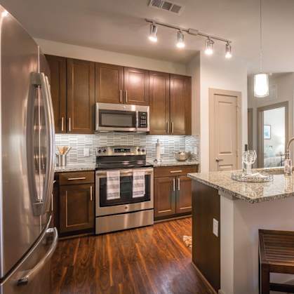 A modern kitchen with wooden cabinets and a granite countertop.