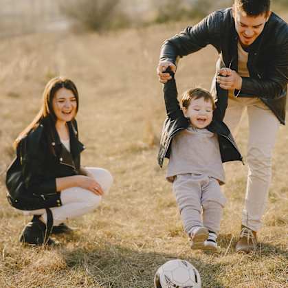 a family playing soccer in a field