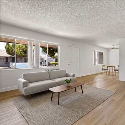 A living room with a grey couch and a wooden coffee table.
