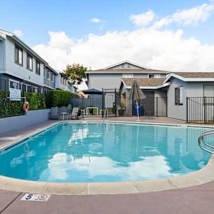 A swimming pool in a residential area with a sign that says "5".