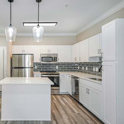 a kitchen with white cabinets and a white island