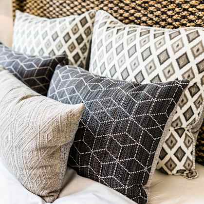 a pile of pillows on top of a bed