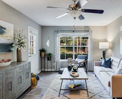 a living room with a white couch and a ceiling fan