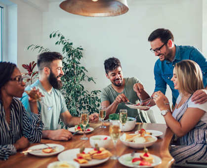 a group of people sitting around a table eating food at The Palms, Charleston