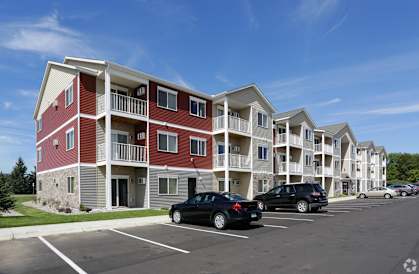 an apartment complex with a parking lot in front of it