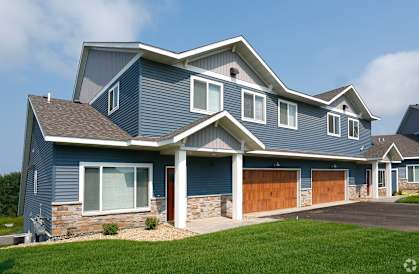 a house with a blue siding and a brown garage door
