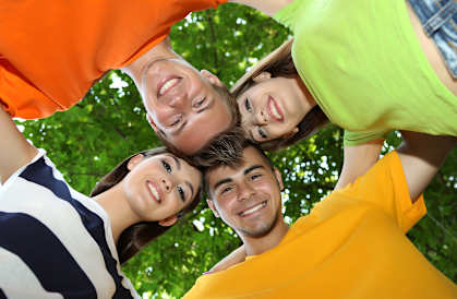 Four people stand in a circle, looking up at the camera.