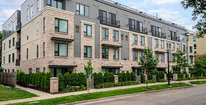 A modern apartment building with a mix of stone and siding exteriors.