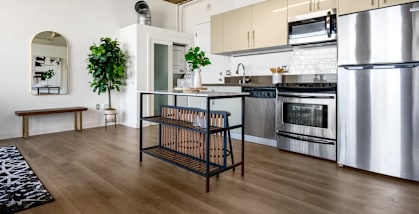 a kitchen with white cabinets and stainless steel appliances and a table