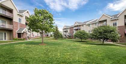 A grassy area in front of apartment buildings.