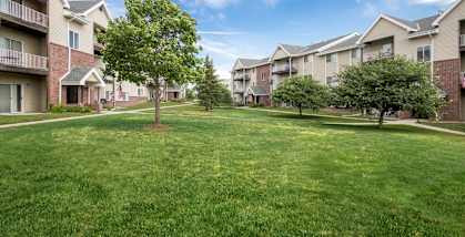 A grassy area in front of apartment buildings.