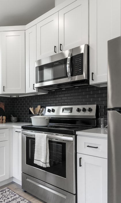 a kitchen with stainless steel appliances and white cabinets