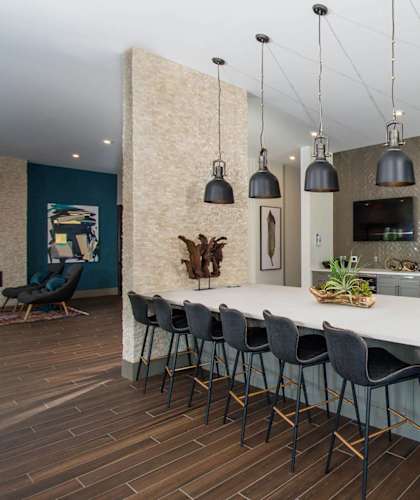 a large kitchen with a white counter top and chairs