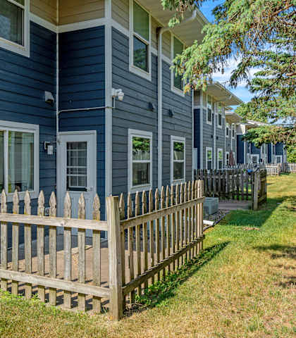 a wooden fence in front of a blue house
