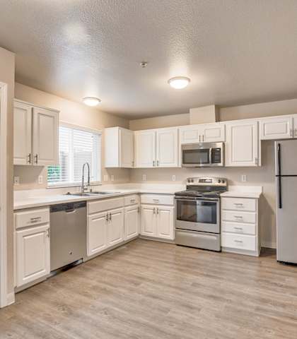A kitchen with white cabinets and appliances.