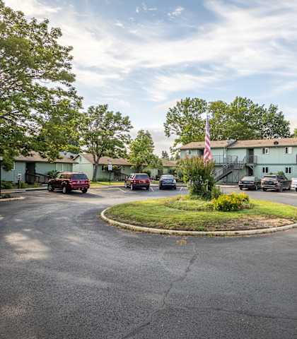 a parking lot with a building and cars in front of it