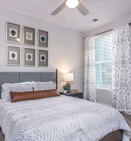 a bedroom with a bed and a ceiling fan at Centro at Pine Nash in North Carolina 27893