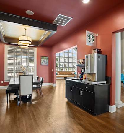 A kitchen with a black countertop and a refrigerator.