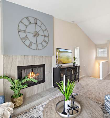 a living room with a fireplace and a large clock on the wall at Northridge, Rochester Hills, Michigan