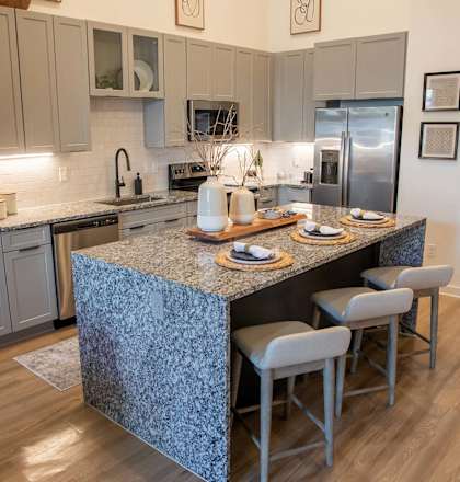 a kitchen with an island and a stainless steel refrigerator at Sterling Nashville West Apartments, Nashville, Tennessee