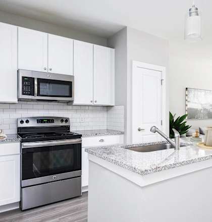 a white kitchen with a sink and a stove