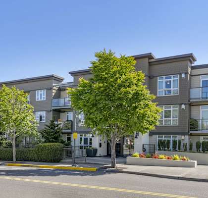 a picture of an apartment building with a blue car parked in front of it at 128 on State, Kirkland, 98033