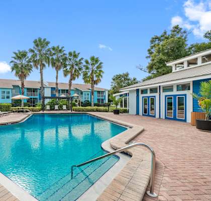 a swimming pool with palm trees in front of a building