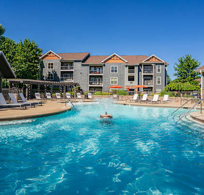 a swimming pool with an apartment building in the background