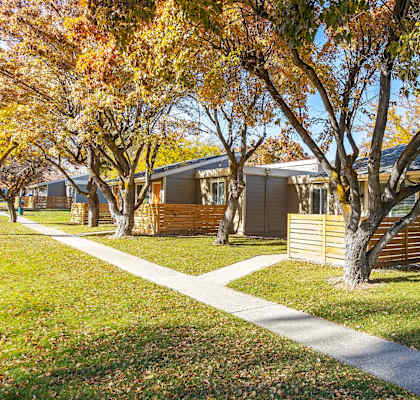 a row of  apartments with trees in front of them