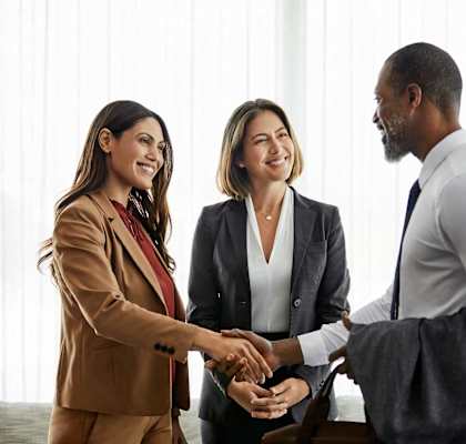 a man and two women shaking hands