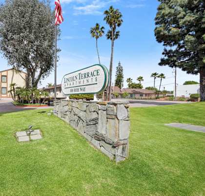 A sign for Lincoln Terrace is in front of a grassy area.