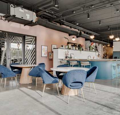 a dining room with blue chairs and tables and a bar