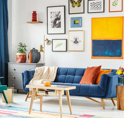 A living room with a blue couch, a green chair, and a wooden coffee table.