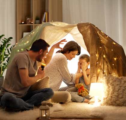 a man and woman sit on the floor in a living room in front of a tent at Willow Grove, Clifton, CO