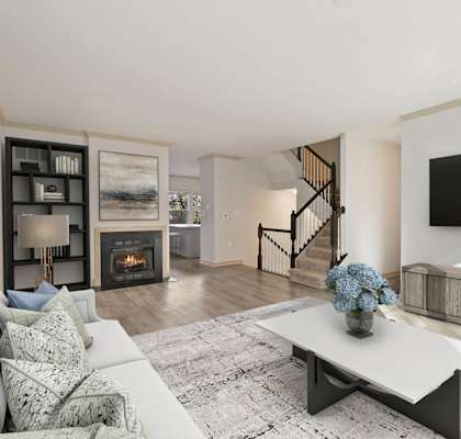A modern living room with a fireplace and a staircase.