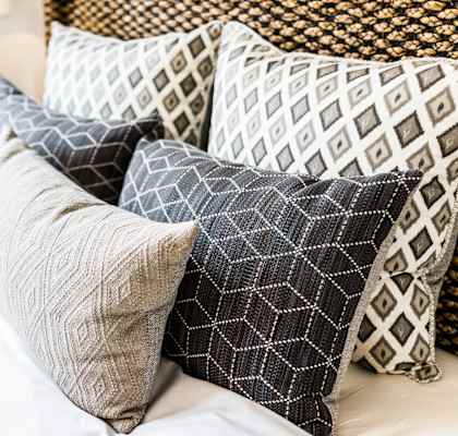 a pile of pillows on top of a bed